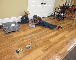 Neighbors | Zack Shively.After pulling the blocks, other groups at the Poland library's Lego WeDo Robots event looked through the programming to experiment with what else the robot could do. Pictured are, from left, Moses, Jack and Max all search through the programming to make their machine move in reverse.
