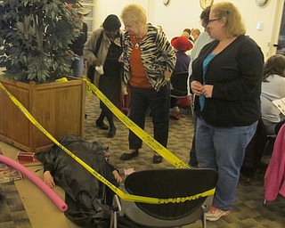 Neighbors | Zack Shively.The Austintown library hosted a murder mystery party in their large meeting room on Oct. 30 for 96 people. As pictured, Alexandria Platt demonstrated how the murder scene looked, complete with a number murder weapons surrounding her.