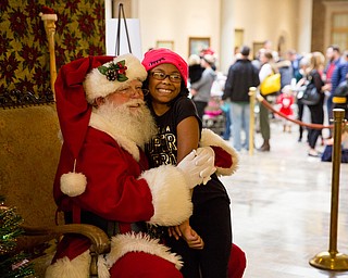Shayna Stewart, 10 of Austintown takes a photo with Santa at the Butler Institute of American Art Family Day on Sunday at the musuem in Youngstown.