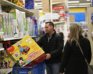 Matt and Ashley Stellato of North Lima load their cart with a Disney Activity Choo Choo during Black Friday shopping, Thursday, Nov. 23, 2017, at the Toys R Us in Boardman...(Nikos Frazier | The Vindicator)