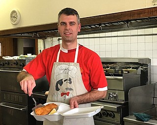 Mike Andjelkovich, volunteer and co-chairman of fish dinners at Holy Trinity Serbian Orthodox Church, shows off a fried haddock dinner. Dinners are served every Friday from 3:30 to 7 p.m. at the church hall. Visit vindy.com to see video of the event.