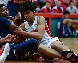 YOUNGSTOWN, OHIO - NOVEMBER 29, 2017: Youngstown State's Michael Akuchie attempts to rip the ball away from Robert Morris's Dachon Burke during the first half of their game Wednesday night at Beeghley Center. Robert Morris won 81-74. DAVID DERMER | THE VINDICATOR