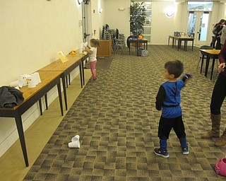 Neighbors | Zack Shively.The Austintown library provided two games during their "Halloween Family Story Time." One game, called "spider cornhole," asked children to throw beanbags onto a board and in a hole. The other game, pictured, was "ghost knockdown" where the children tossed beanbags at a stack of ten cups.