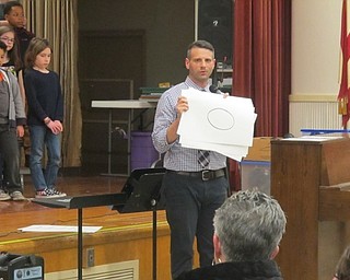 Neighbors | Zack Shively.The third-grade students sang Woody Guthrie's "This Land is Your Land," in which they focused on sustaining notes for whole measures. Pictured, Robert Pavalko shows the audience the types of rhythms the third grade learned in Guthrie's song.