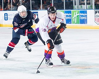 Scott R. Galvin | The Vindicator.Youngstown Phantoms right wing Chase Gresock (19) skates the puck to the goal past USA NTDP's Case McCarthy during the second period at the Covelli Centre on Friday night.