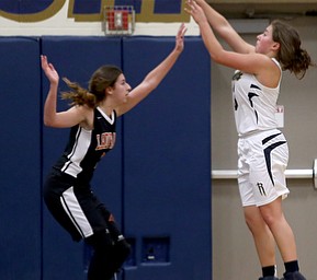 Lowellville's Maddie Kelly (3) goes up for three as Mineral Ridge's Kalyn Stricklin (2) attempts to block her shot during the fourth quarter as Mineral Ridge High School takes on Lowellville High School, Monday, Dec. 4, 2017, at Lowellville High School in Lowellville. Mineral Ridge won 45-33...(Nikos Frazier | The Vindicator)..