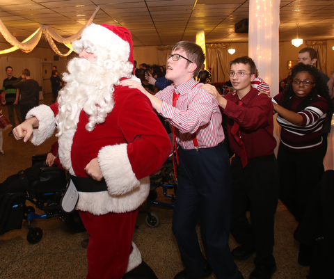 Santa leads the conga line during the 13th annual Winterfest special needs dance, Wednesday, Dec. 6, 2017, at the Mahoning Country Club in Girard...(Nikos Frazier | The Vindicator)