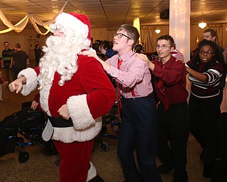 Santa leads the conga line during the 13th annual Winterfest special needs dance, Wednesday, Dec. 6, 2017, at the Mahoning Country Club in Girard...(Nikos Frazier | The Vindicator)