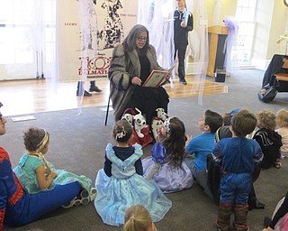 Neighbors | Zack Shively.Volunteer Michelle Zidian read "101 Dalmations" While dressed as Cruella de Vil from the book. The children and parents, dressed as princesses and superheroes, sat on the floor during story time.