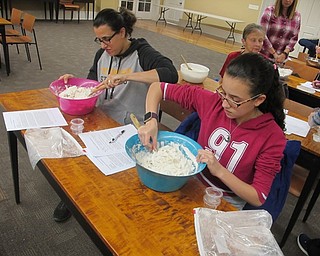 Neighbors | Zack Shively.Participants at the Poland library's "No Knead to Need" event brought their own bowls and mixing sticks to prep for their own no-knead bread. Pictured, from left, Lana Ilain and Serene Awad mix together ingredients.