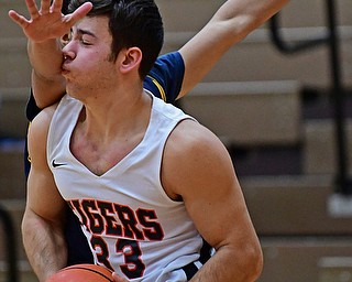 HOWLAND, OHIO - DECEMBER 12, 2017: Howland's Kevin Moamis looks to pass while being tightly guarded by East's Elmer Alvarez Montes during the first half of their game, Tuesday night at Howland High School. DAVID DERMER | THE VINDICATOR