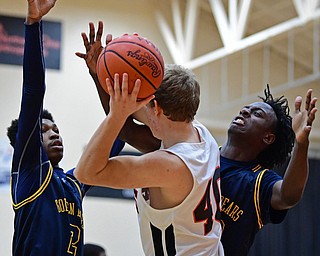 HOWLAND, OHIO - DECEMBER 12, 2017: Howland's Nathan Barrett, center, looks to pass while being guarded by East's Marquel Gillespie, left, and Dontraile Price during the first half of their game, Tuesday night at Howland High School. DAVID DERMER | THE VINDICATOR