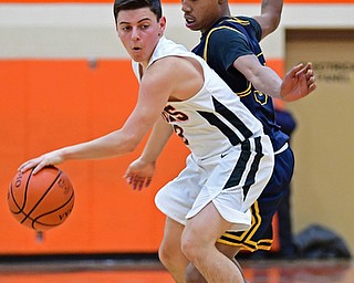 HOWLAND, OHIO - DECEMBER 12, 2017: Howland's Frank Rappach spins away from East's Angelo Evans during the first half of their game, Tuesday night at Howland High School. DAVID DERMER | THE VINDICATOR