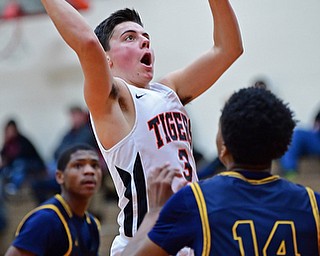 HOWLAND, OHIO - DECEMBER 12, 2017: Howland's Frank Rappach shoots over East's Dallas Heard during the first half of their game, Tuesday night at Howland High School. DAVID DERMER | THE VINDICATOR