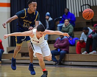 HOWLAND, OHIO - DECEMBER 12, 2017: Howland's Frank Rappach has the ball knocked away from him by East's Angelo Evans during the first half of their game, Tuesday night at Howland High School. DAVID DERMER | THE VINDICATOR