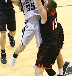 MCDONALD, OHIO - DECEMBER 15, 2017: McDonald's Zach Rasile (25) drives to the hopp as Springfield's Brandon Walters (3) and Springfield's John Ritter (13)  defend during the 1st qtr at McDonald High School.  MICHAEL G. TAYLOR | THE VINDICATOR