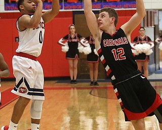 Austintown Fitch forward Randy Smith (0) goes up for three as Canfield's guard Ethan Kalina (12) attempts to block his shot in the third quarter of an AAC high school basketball game, Saturday, Dec. 16, 2017, in Austintown. Canfield won 77-57...(Nikos Frazier | The Vindicator)