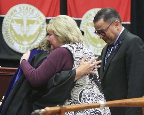 William D Lewis The Vindicator  David and Pat Leo, parents of slin Girard Police Officer Justin Leo embrace Kristine Blair, dean of college of Liberal Arts and social sciences during 12-17-17 commencement ceremony where their was awarded a YSU degree.
