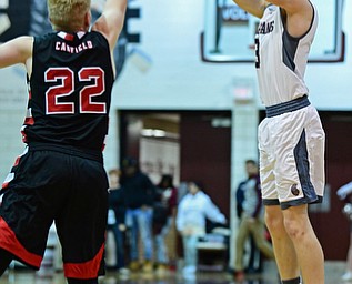 BOARDMAN, OHIO - DECEMBER 19, 2017: Boardman's Holden Lipke shoots a three point shot over Canfield's Ian McGraw during the first half of their game, Tuesday night at Boardman High School. DAVID DERMER | THE VINDICATOR