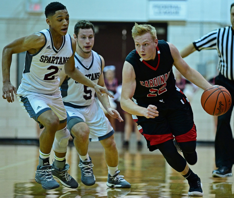 BOARDMAN, OHIO - DECEMBER 19, 2017: Canfield's Ian McGraw drives on Boardman's Ryan Archey and Mike Melewski during the first half of their game, Tuesday night at Boardman High School. DAVID DERMER | THE VINDICATOR