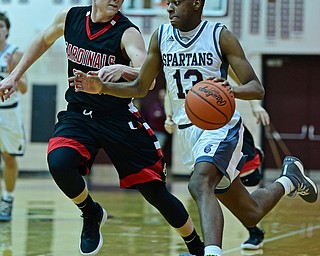 BOARDMAN, OHIO - DECEMBER 19, 2017: Boardman's Che Trevena drives on Canfield's Ian McGraw during the second half of their game, Tuesday night at Boardman High School. DAVID DERMER | THE VINDICATOR