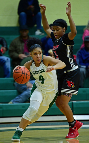 YOUNGSTOWN, OHIO - DECEMBER 20, 2017: Ursuline's Nomiki Willis drives on Shaw's Paula Taylor during the first half of their game, Tuesday night at Ursuline High School. DAVID DERMER | THE VINDICATOR