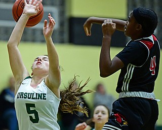 YOUNGSTOWN, OHIO - DECEMBER 20, 2017: Ursuline's Cara McNally has the ball knocked away from her by Shaw's Deleah Gibson during the first half of their game, Tuesday night at Ursuline High School. DAVID DERMER | THE VINDICATOR
