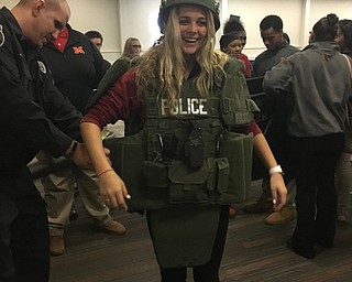 Neighbors | Submitted.Cardinal Mooney's Career Exploration Day ended with a law enforcement panel. Pictured, Junior Alexis Saunders tried out Boardman Police Officer John Gocala's (Mooney Class '98) gear.