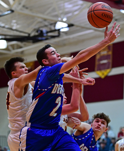 CANFIELD, OHIO - DECEMBER 22, 2017: Western Reserve's Dom Velasquez reaches for a rebound while fighting with South Range's Jake Gehring during the first half of their game on Friday night at South Range High School. DAVID DERMER | THE VINDICATOR