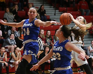 Canfield guard Emerson Fletcher (14) goes up for a layup as Poland forward Kailyn Brown (14) and Poland guard Kat Partika (22) fly past her in the third quarter of an AAC high school basketball game, Friday, Dec. 23, 2017, in Canfield. Canfield won 45-34...(Nikos Frazier | The Vindicator)