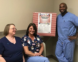 Neighbors | Submitted.Doctors and staff from Ankle & Foot Care Centers are hoping to collect hundreds of pairs of shoes and socks for their 20th annual holiday shoe drive. Pictured, from left, are Terri Prentice, Tina Adkins and Dr. Kwame Williams at the Liberty office.