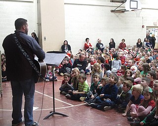 Neighbors | Zack Shively.Joel Monaco, along with Michele Prokop, sang Christmas tunes at Stadium Elementary. Pictured, principal Michael Zoccali, near center, joined the students in the holiday cheer.