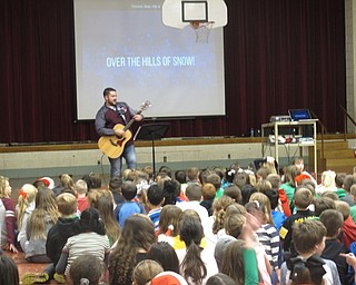 Neighbors | Zack Shively.Michele Prokop helped Joel Monaco with the sing along by singing and operating the slide presentation on the projector which had the  lyrics to the holiday songs Monaco sang.