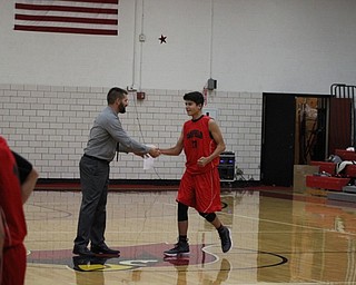 Neighbors | Abby Slanker.Jake Grdic, a member of the eighth-grade boys basketball team, was met by boys varsity Head Coach Todd Muckleroy as he was introduced during the Meet the Team Rally at Canfield High School on Nov. 16.