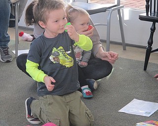 Neighbors | Zack Shively.Steed brought out shakers for a song called "Shake Your Shakers," a song in the tune of "The London Bridge Is Falling Down." The children had directions to shake the shakers by different parts of their body, such as their nose, as pictured.