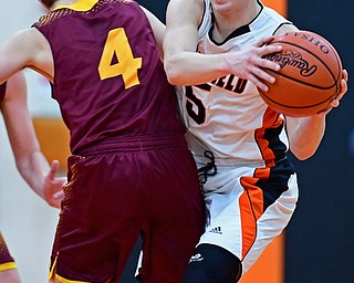 NEW MIDDLETOWN, OHIO - DECEMBER 29, 2017: Springfield's Clay Medvec secures the basketball while colliding with South Range's Brennan Troy during the first half of their game on Friday night at Springfield High School. DAVID DERMER | THE VINDICATOR