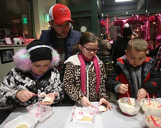 Jim Johnstone of Boardman(YSU hat) watches as his kids(from left), Ryley(10), Hayley(8) and Brayden(5) decorate cookies during First Night Youngstown, Sunday, Dec. 31, 2017, at One Hot Cookie in Youngstown. ..(Nikos Frazier | The Vindicator)