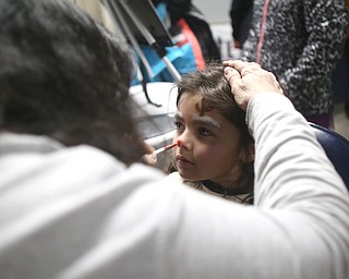 Ariana McDonough(5) of Canfield gets a reindeer face painted by Maria Jones of New Castle during First Night Youngstown, Sunday, Dec. 31, 2017, at LOCATION in Youngstown. ..(Nikos Frazier | The Vindicator)