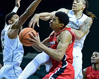 YOUNGSTOWN, OHIO - JANUARY 1, 2018: Youngstown State's Devin Haygood goes to the basket while being pressured by Cleveland State's Jamarcus Hairston and Anthony Wright during the first half of their game on Saturday afternoon at the Wolstein Center. Youngstown State won 80-77. DAVID DERMER | THE VINDICATOR
