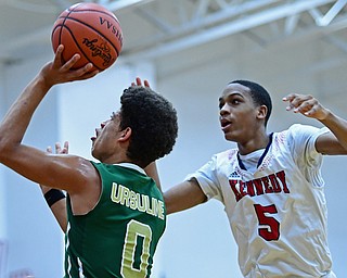 WARREN, OHIO - JANUARY 2, 2017: Ursuline's Ryan Clark goes to the basket while JFK's JFK's Tyler James watches during the first half of their game on Tuesday night at Warren JFK High School. DAVID DERMER | THE VINDICATOR