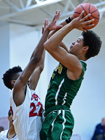 WARREN, OHIO - JANUARY 2, 2017: Ursuline's Ryan Clark goes to the basket against JFK's Ethan Courtney during the first half of their game on Tuesday night at Warren JFK High School. DAVID DERMER | THE VINDICATOR