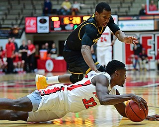 YOUNGSTOWN, OHIO - JANUARY 4, 2017: Youngstown State's Garrett Covington falls to the floor to grab the ball away from Milwaukee's Jeremiah Bell during the first half of their game, Thursday night at Beeghly Center. DAVID DERMER | THE VINDICATOR