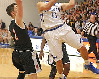 Brandon Barringer (13) of Poland goes up for a shot while being defended by Issiah Torrence (1) of Struthers during the second half of Thursday nights matchup at Poland High School. Dustin Livesay  |  The Vindicator  1/4/18  Poland