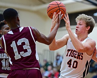 HOWLAND, OHIO - JANUARY 5, 2018: Howland's Nathan Barrett reaches for the ball with Boardman's Che Trevena after Barrett lose control of it during the first half of their game, Friday night at Howland HigH School. DAVID DERMER | THE VINDICATOR