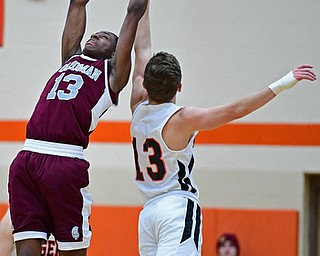 HOWLAND, OHIO - JANUARY 5, 2018: Boardman's Che Trevena leaps to secure the ball away from Howland's Connor Tomarkin during the second half of their game, Friday night at Howland HigH School. DAVID DERMER | THE VINDICATOR