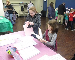 Neighbors | Zack Shively.Jennifer Kuczek organized a few crafts for the children to do at the Nutcracker party. Pictured, two children cut out paper dolls at the "Princess Pirlipat's Paper Dolls" station.