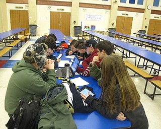 Neighbors | Zack Shively.After seeing the game and the ways to score in the competition, the robotics students began to brainstorm ways to design their robots. Pictured is Austintown's robotics team working together to plan their designs.