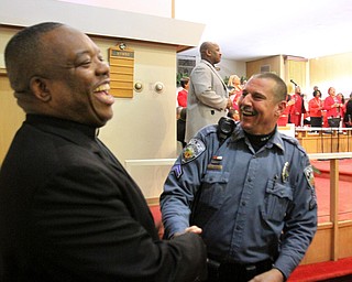 William D Lewis the vindicator  Rev Joseph walker president of Trumbull County Interdenominational Ministerial Alliance shres moment with Brookfield PD officer Ron Mann during MLK community seervice at Second Baptist Church in Warren.