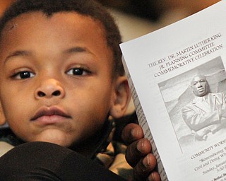 William D. Lewis the vindicator  Janero Jackson, 4, of Youngstown pauses near a picture of Rev MLK Jr on a program  during MLK communioty worship service at New Bethel Baptist Church in Youngstown 1-14-18. He was attending the event with his mother Stephanie Buck.