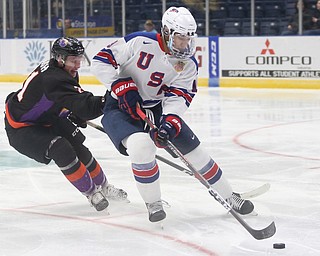 Team USA defenseman K'Andre Miller (19) keeps the puck away from Youngstown Phantoms center Mike Regush (21) in the second period of an USHL regular season hockey game, Monday, Jan. 15, 2018, in Youngstown. Team USA won 7-1...(Nikos Frazier | The Vindicator)